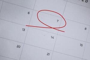 Focus on number 7 in calendar and emptyred ellipse. Save the date. Day of the year concept. photo