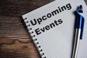 Concept of upcoming events on book isolated on Wooden Table. photo