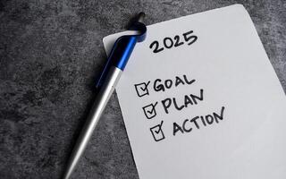 Concept of Checklist for 2025 Goals, plan, action with check marks write on paperwork isolated on Wooden Table. symbolizing planning and achieving photo