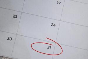 Focus on number 31 in calendar and emptyred ellipse. Save the date. Day of the year concept. photo