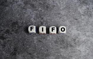 The businessman abbreviation FIFO - First in First Out on wooden blocks or dice photo