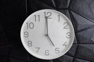 time in clock of five o'clock for design in your business concept isolated on black background. photo