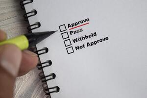 Concept of pointing Approve and underlined in red color write on paperwork isolated on Wooden Table. photo