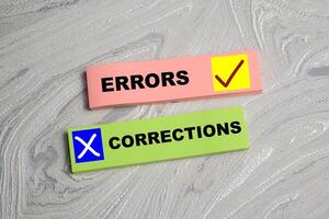Concept of Corrections Errors write on sticky notes isolated on Wooden Table. photo