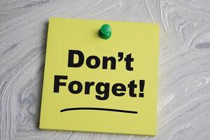 Concept of Dont forget write on sticky notes isolated on Wooden Table. photo