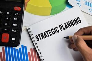 Concept of Strategic Planning write on book isolated on Wooden Table. photo