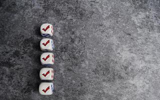 Wooden cubes or dice with check mark on the table. Checklist concept photo