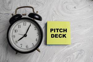 Concept of Pitch Deck write on sticky notes isolated on Wooden Table. photo