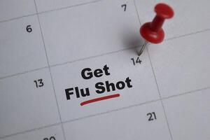 14th day of the month. writing text Get flu shot on calendar date. Save the date. Day of the year concept. photo