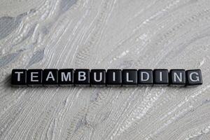 Concept of Team building written on wooden blocks. Cross processed image on Wooden Background photo