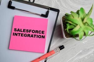 Concept of Salesforce Integration write on sticky notes isolated on Wooden Table. photo