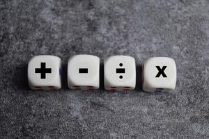 Basic mathematical operation symbols. Plus, minus, multiply and divide symbols on wooden cubes or dice. Basic calculate for business concept photo