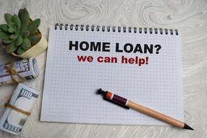 Concept of Home Loan. We can help write on book isolated on Wooden Table. photo