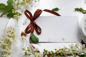 Beautiful tea setup with blank card and fresh flowers, perfect for invitations or notes in a cozy setting photo