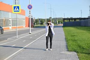white shirt or jacket that is partially open. 4. Behind her is a building with a bright photo