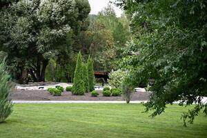 Scenic View of a Beautiful English Style Landscape Garden with a Green Mowed Lawn and Colourful Flower Bed photo