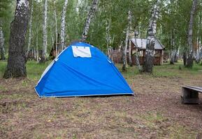 A woman sets up a tent in the forest. Concept of a Journeys and tourism. photo
