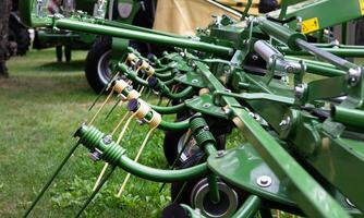 The image showcases a close-up view of a green agricultural machine. photo