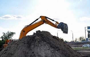 blue sky background. Construction machinery and earth-moving heavy equipment for excavation, loading, lifting and hauling of cargo on job sites photo