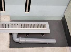 Drain in the shower stall. Sewer pipes. photo
