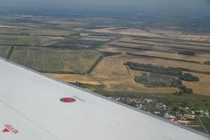 Commercial airplane while flying against a clear blue sky in motion with copy space. Looking through the plane window. photo