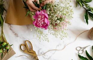 A pair of vintage-style scissors lies near the wrapped flowers. photo