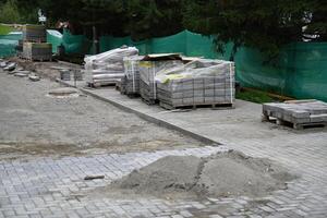 Leveling sand and cement tiles for precise pavement of the outside patio or sidewalk. Construction industry and renovation. photo