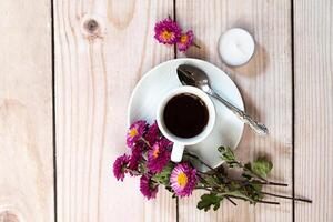 Autumn composition. Cup of coffee, notepad, fresh flowers on white background. Autumn, fall concept. Flat lay, top view, copy space photo