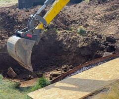 Close up view of excavator bucket digging ground on construction site photo