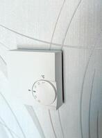Modern thermostat for setting and maintaining the temperature in the house. Heating by the system of warm floors photo