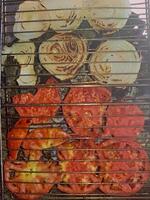 A close-up view of onions and tomatoes as they roast on the grill photo