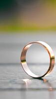 Two wedding rings standing together on a wooden surface, The image highlights the symbol of unity and commitment in marriage. video