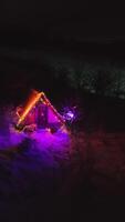 Christmas time. Cozy Cabin with Festive Lights in Winter Nigh, A charming small cabin with colorful festive lights in a snowy winter setting video