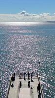 Aerial view of a sparkling ocean with pier, people enjoying the view at Coney Island Beach video