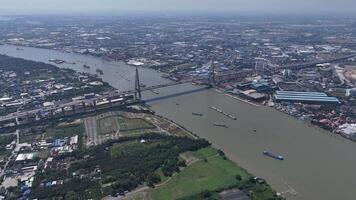 Aerial view of a large river running through an urban area, featuring a prominent cable-stayed bridge with multiple lanes for vehicles. video