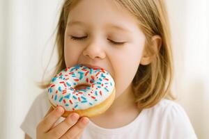 A little girl happily eats a donut with colorful sprinkles, USA Donut Day, Fat Thursday photo
