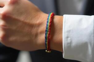 Close-up of hand wearing rainbow friendship bracelet symbolizing diversity and inclusion photo