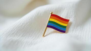 Rainbow flag pin on white fabric symbolizing pride and diversity. photo