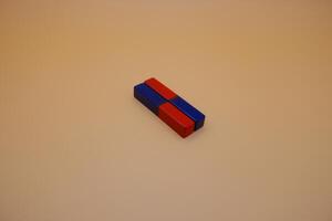 Two Red and Blue Rectangular Magnets on Minimalist Background photo