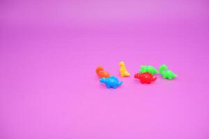 Fun Dinosaur Figures in Bold Colors on Purple Background photo