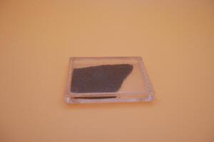Fine Iron Sand Stored in Sealed Transparent Container photo