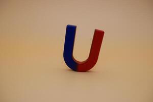 Red and Blue U Magnet Standing Upright on Beige Surface photo