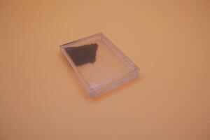 Iron Sand Inside Display Box Isolated on Beige photo