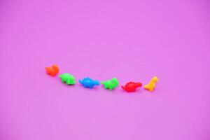 Bright Plastic Dinosaur Figurines Arranged on Violet Surface photo