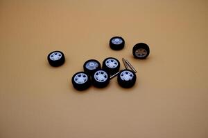 Mini Plastic Toy Wheels and Axles on Yellow Background photo