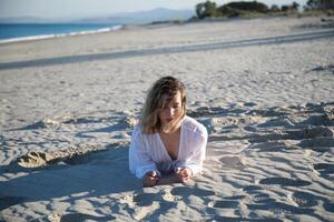 Girl Dressed In White Posing On The Mediterranean Sand Near The Ocean In Summer photo