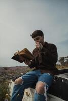 Christian Man Reading A Prayer On The Bible Book While On The Beach During Summer photo