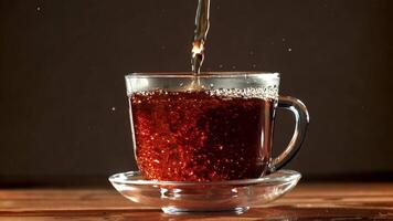 Black tea is poured into a cup. Filmed on a high-speed camera at 1000 fps. High quality FullHD footage video