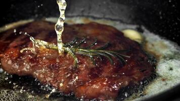 Beef steak in a pan with garlic and spices. Filmed on a high-speed camera at 1000 fps. High quality FullHD footage video