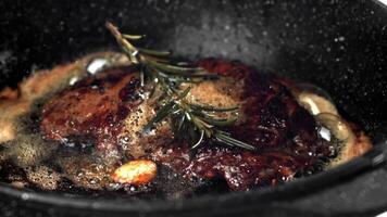 Beef steak in a pan with garlic and spices. Filmed on a high-speed camera at 1000 fps. High quality FullHD footage video